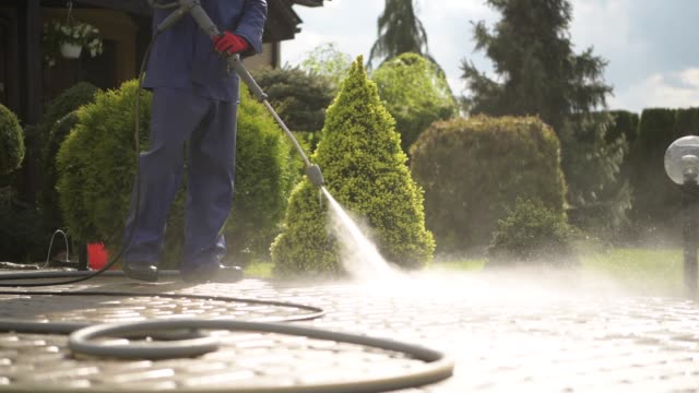 Men Using Pressure Washer For Driveway Cleaning.